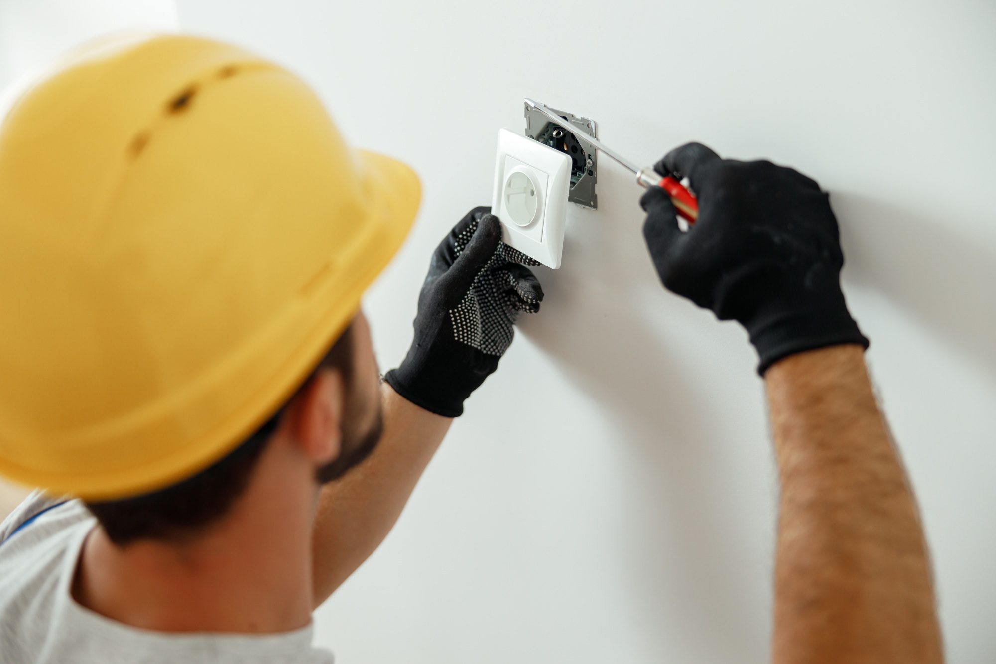 professional-electrician-in-uniform-using-screwdriver-while-installing-electrical-socket-outlet.jpg